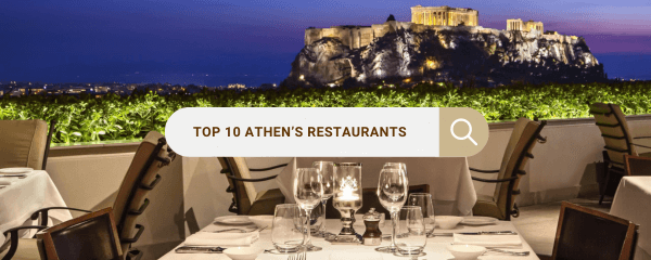 Outdoor dining setup with a view of the illuminated Acropolis in Athens at night. A search bar overlay in the center reads 'Top 10 Athen's Restaurants,' symbolizing a search for top dining spots in the city